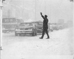 Policeman directing traffic in a blizzard by The Buffalo Courier-Express Newspaper