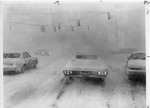 Snowy intersection with cars driving through