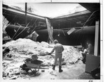 Two men shoveling snow inside collapsed building